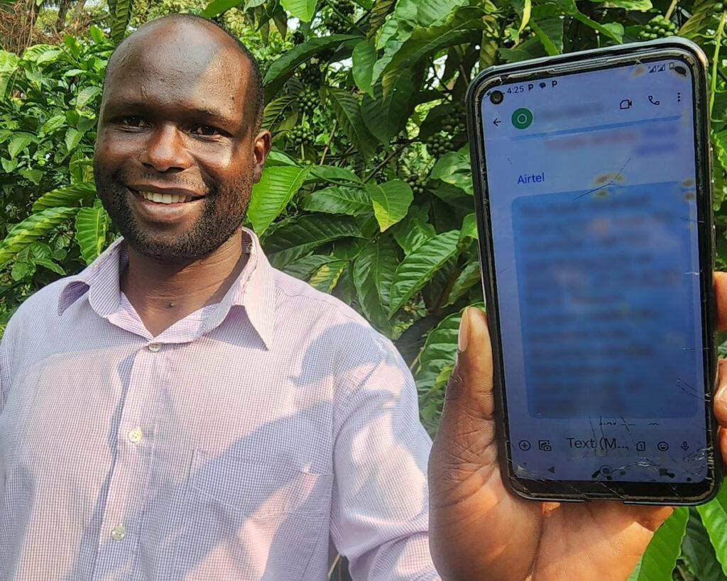 Farmer hält Handy in Hand, das eine Nachricht zeigt