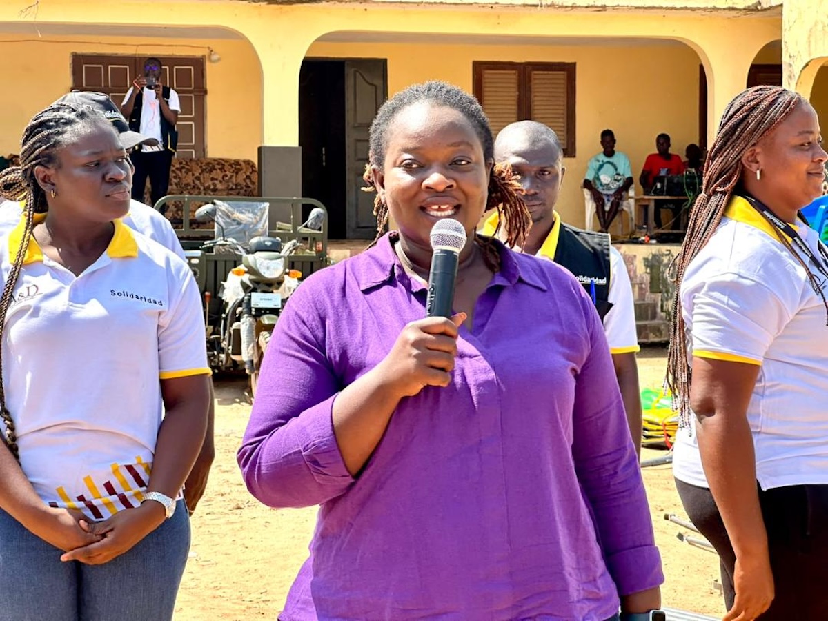 Olive M’Bahia, Ländervertreterin von Solidaridad Côte d’Ivoire, spricht bei einer feierlichen Übergabe von landwirtschaftlichen Geräten an Kakaobäuerinnen in der Elfenbeinküste zur Förderung der finanziellen Unabhängigkeit.